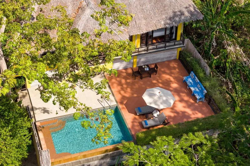 Vue aérienne d'une terrasse en bois avec piscine et mobilier de jardin.