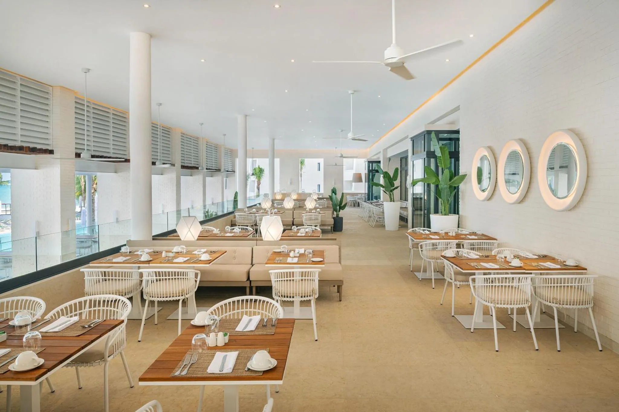 Une salle lumineuse avec des tables dressées pour le repas.