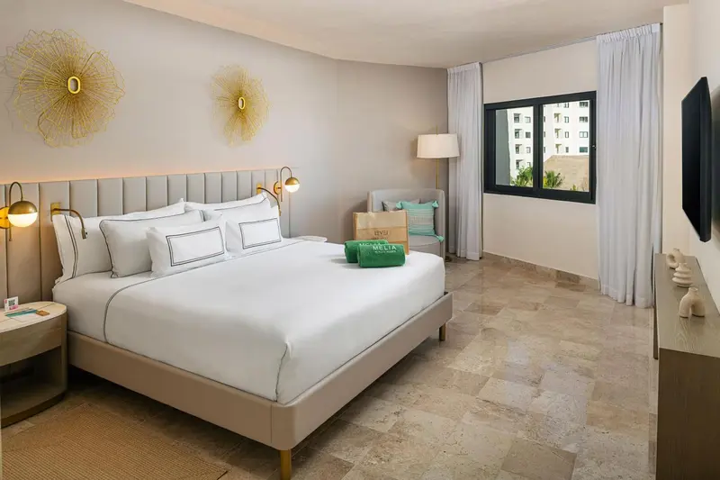 Une chambre lumineuse avec un grand lit et une décoration sobre.