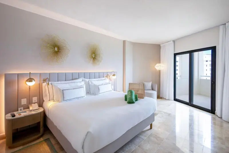 Une chambre lumineuse avec un grand lit et un accès à une terrasse.