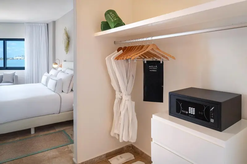 Une chambre lumineuse avec un grand lit et un espace rangement.