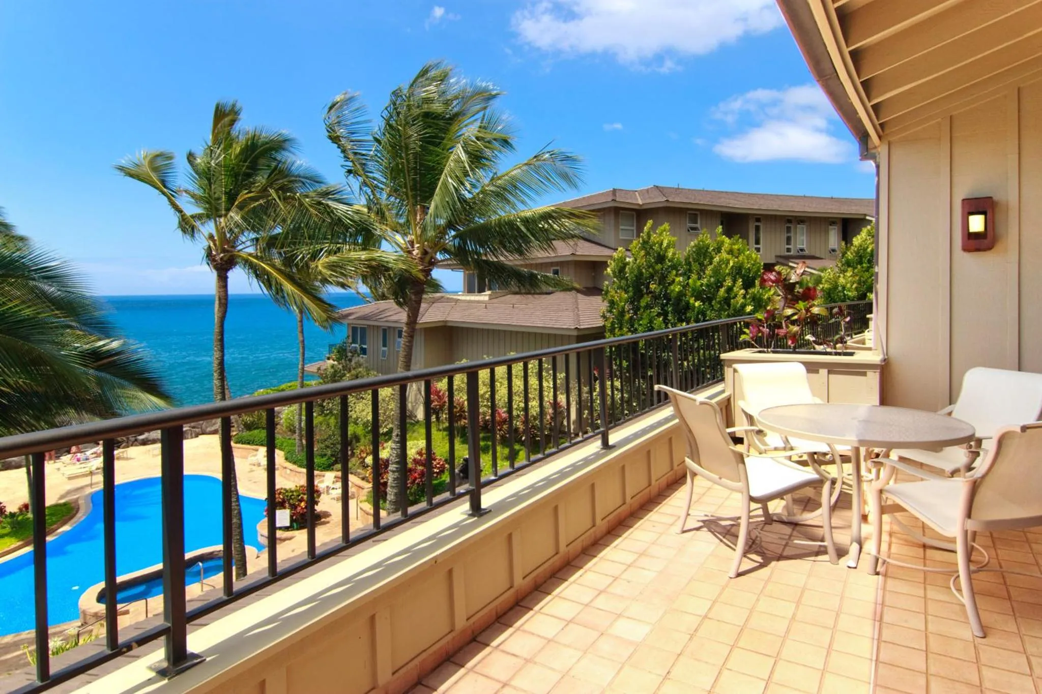 Une terrasse ensoleillée offre une vue sur la mer et une piscine.