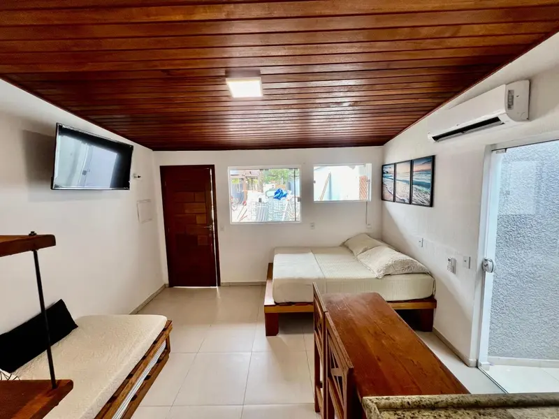 Une chambre lumineuse avec deux lits simples et un accès à l'extérieur.