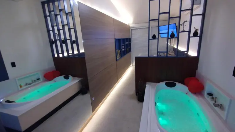 Deux baignoires d'angle éclairées dans une salle de bain moderne.