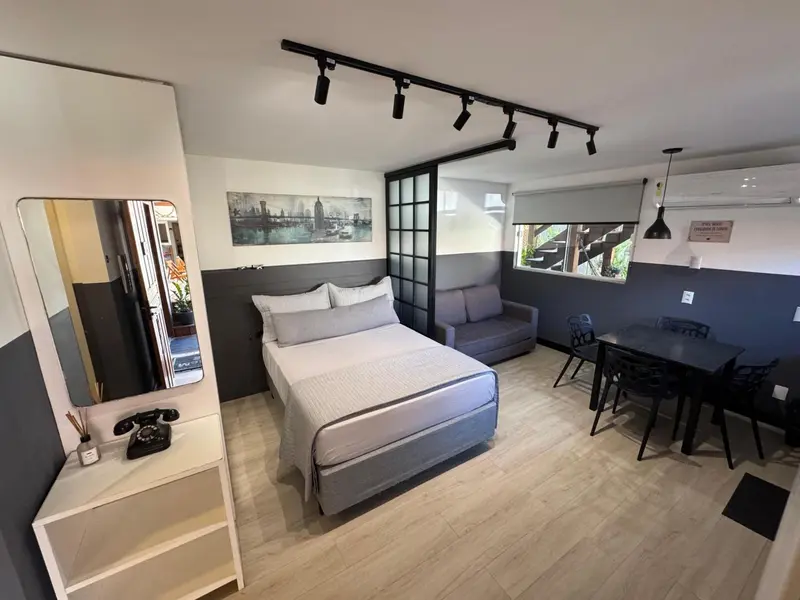 Une chambre lumineuse avec un lit double, un canapé et une table.