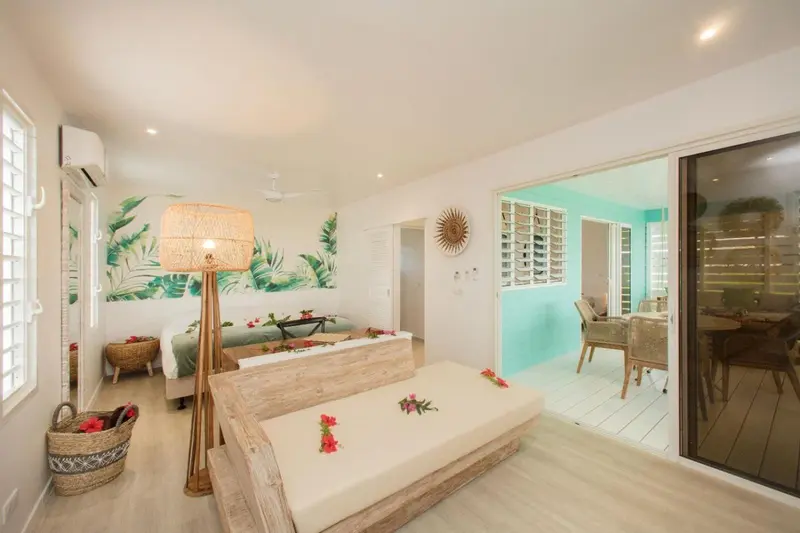 Une chambre lumineuse avec un lit décoré de fleurs et un accès à une terrasse.