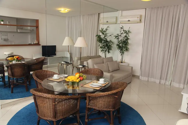 Espace de vie lumineux avec coin repas et canapé.