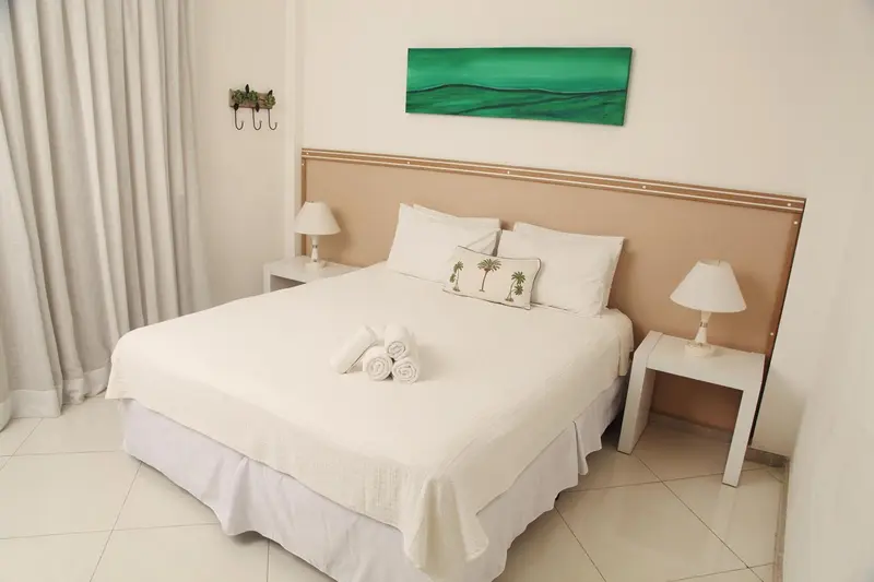 Une chambre lumineuse avec un grand lit recouvert de draps blancs.
