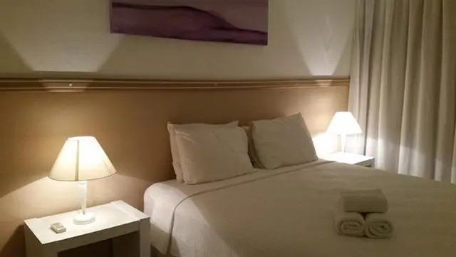 Une chambre lumineuse avec un grand lit et des tables de chevet.