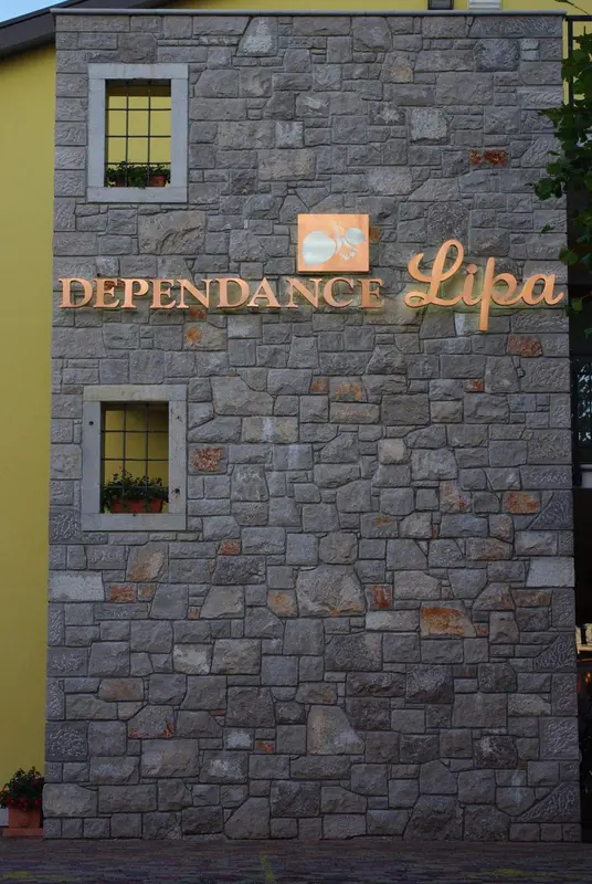 Façade en pierre d'un bâtiment avec une inscription dorée.