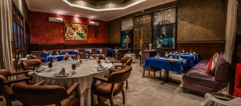 Une salle à manger élégante avec des tables dressées et des banquettes confortables.