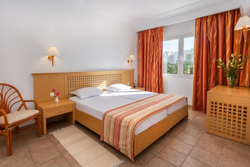 Une chambre lumineuse avec un lit double et une décoration sobre.