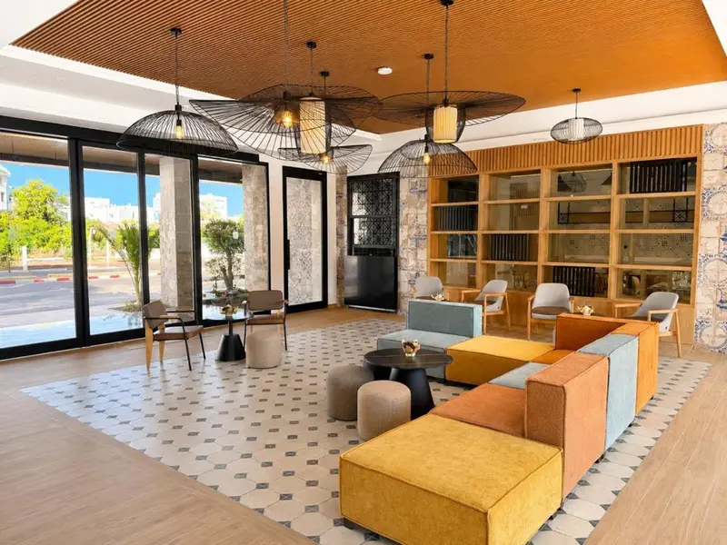 Un espace de détente intérieur avec des canapés colorés et un sol à motifs.