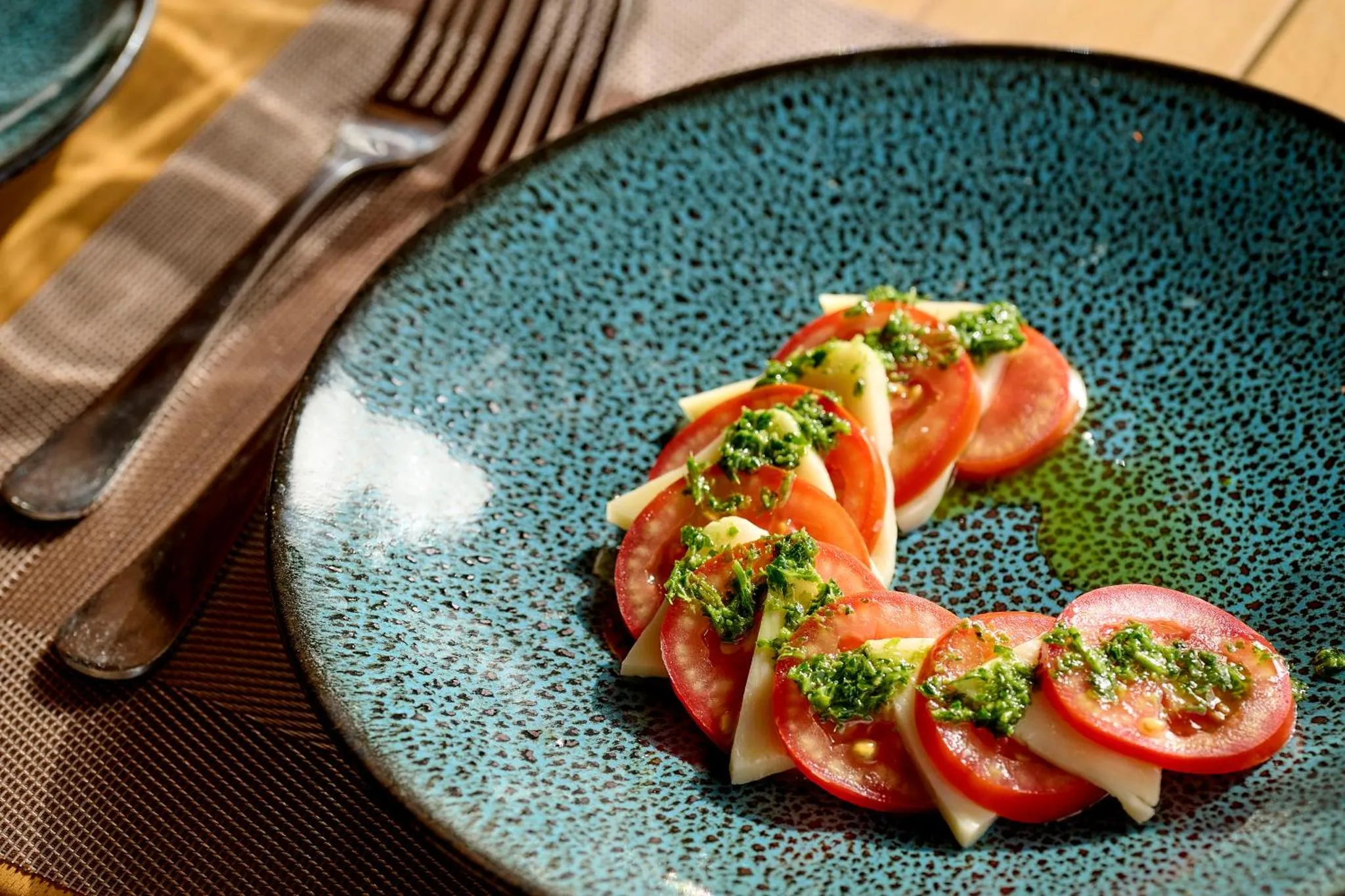 Assiette de salade caprese avec des tomates, de la mozzarella et du basilic.