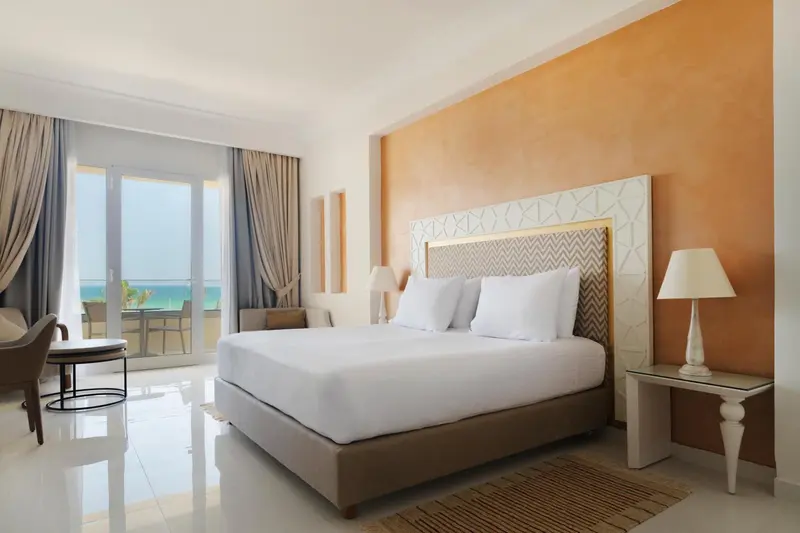 Une chambre lumineuse avec un grand lit et une vue sur la mer.