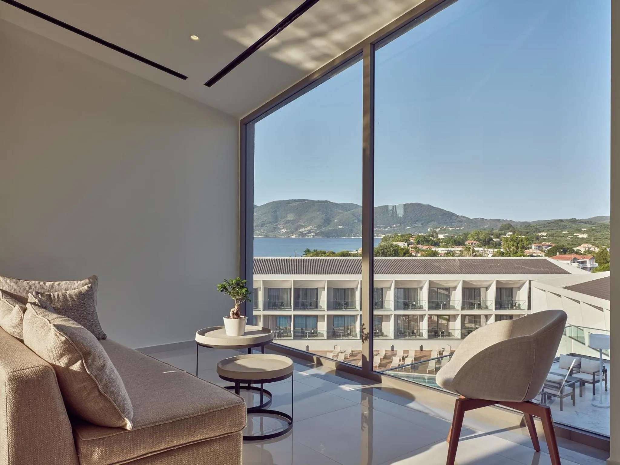 Espace de détente intérieur avec canapés et vue sur la mer.