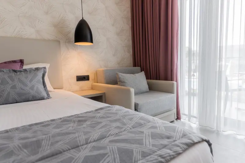 Une chambre lumineuse avec un lit confortable et un coin salon.