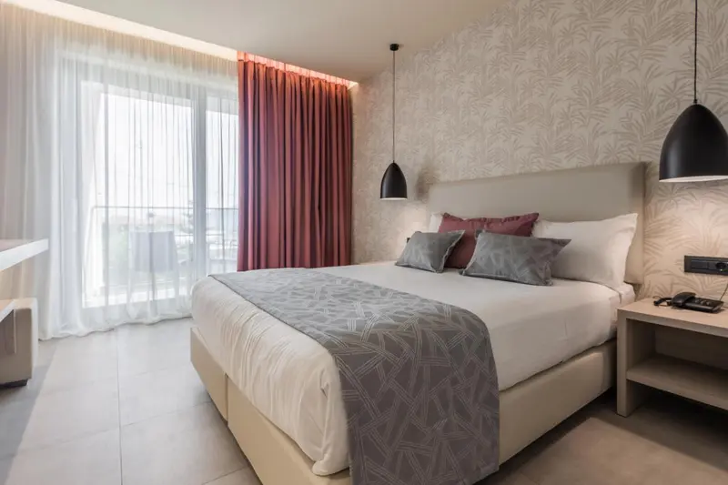 Une chambre lumineuse avec un grand lit et des rideaux.