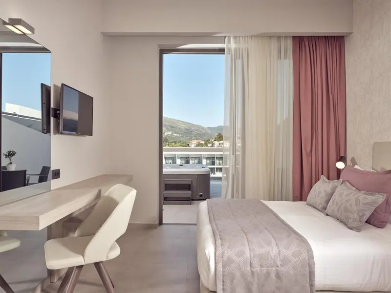 Une chambre lumineuse avec un lit et un bureau donnant sur une vue dégagée.
