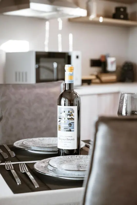 Une table est dressée avec de l'argenterie et une bouteille de vin.