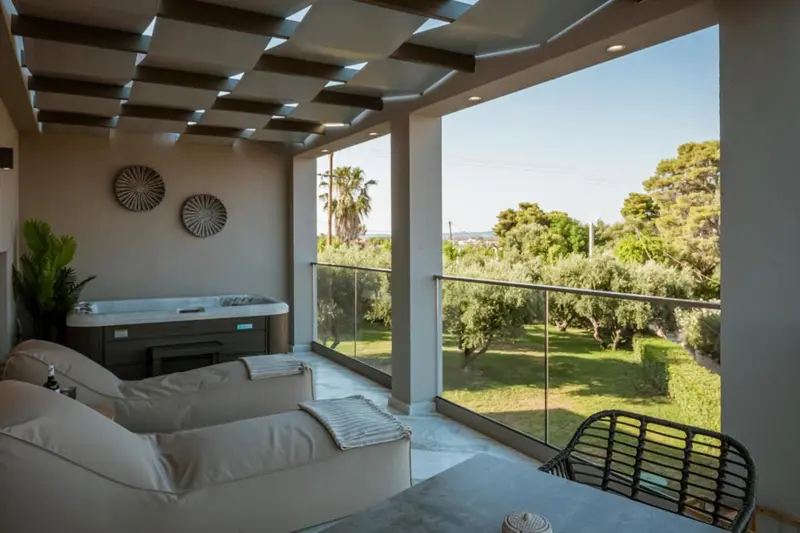 Espace détente extérieur avec jacuzzi et mobilier de jardin.