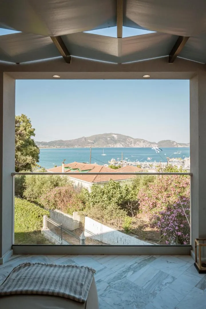 Vue sur la mer et la côte depuis une terrasse ombragée.