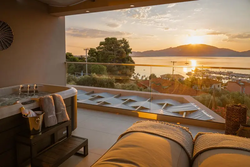 Terrasse avec jacuzzi et vue sur la mer au coucher du soleil.