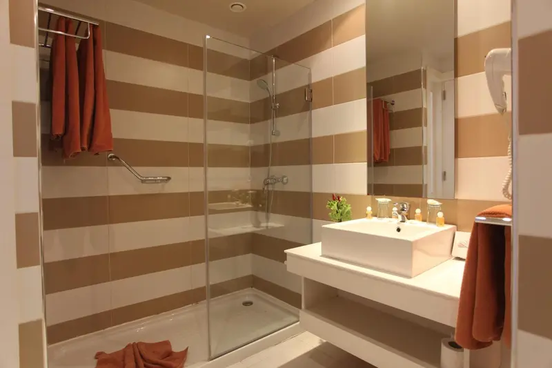 Une salle de bain moderne avec douche à l'italienne et lavabo blanc.