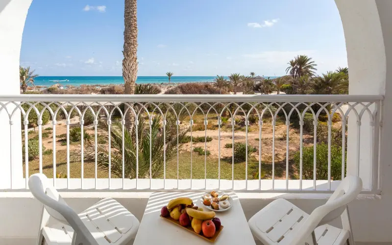 Vue sur la plage et la végétation depuis un balcon.