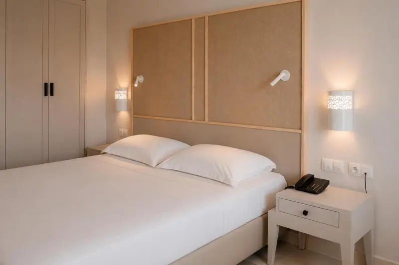 Une chambre lumineuse avec un grand lit et des tables de chevet.