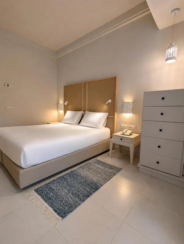 Une chambre lumineuse avec un grand lit et une commode.