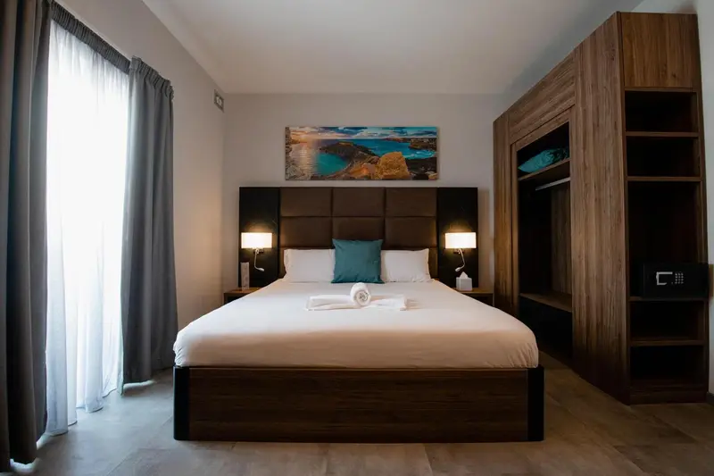 Une chambre d'hôtel moderne avec un grand lit et un décor sobre.