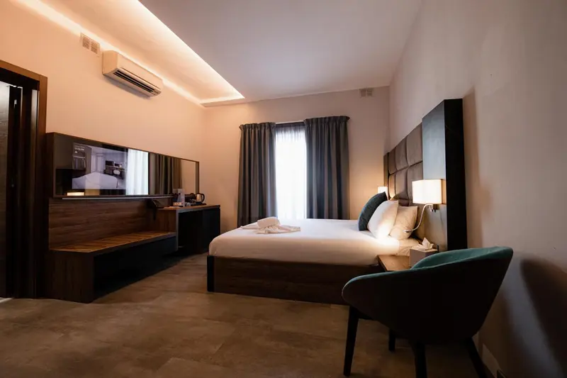 Une chambre lumineuse avec un grand lit et un espace détente.