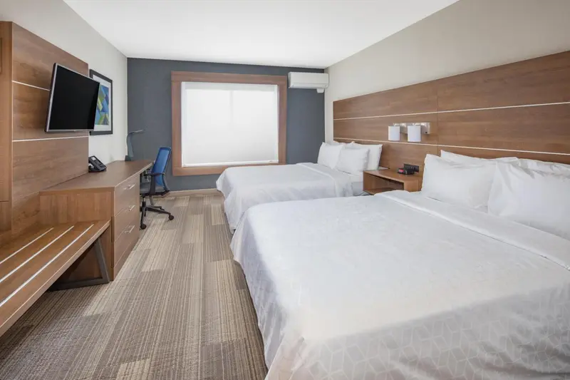 Une chambre d'hôtel avec deux lits et un bureau.