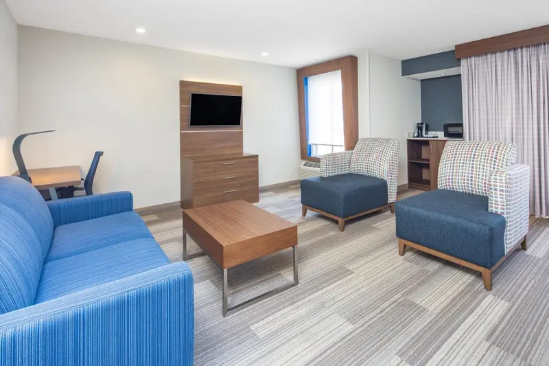 Un espace de séjour lumineux avec canapés et fauteuils.