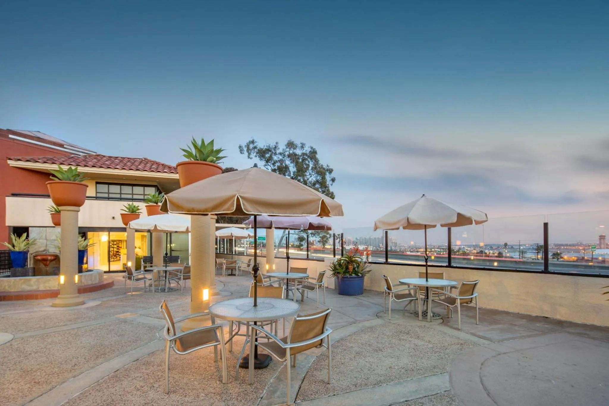 Terrasse aménagée avec parasols et mobilier de jardin face à la mer.