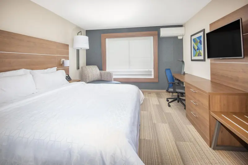 Une chambre d'hôtel lumineuse avec un grand lit et un espace de travail.