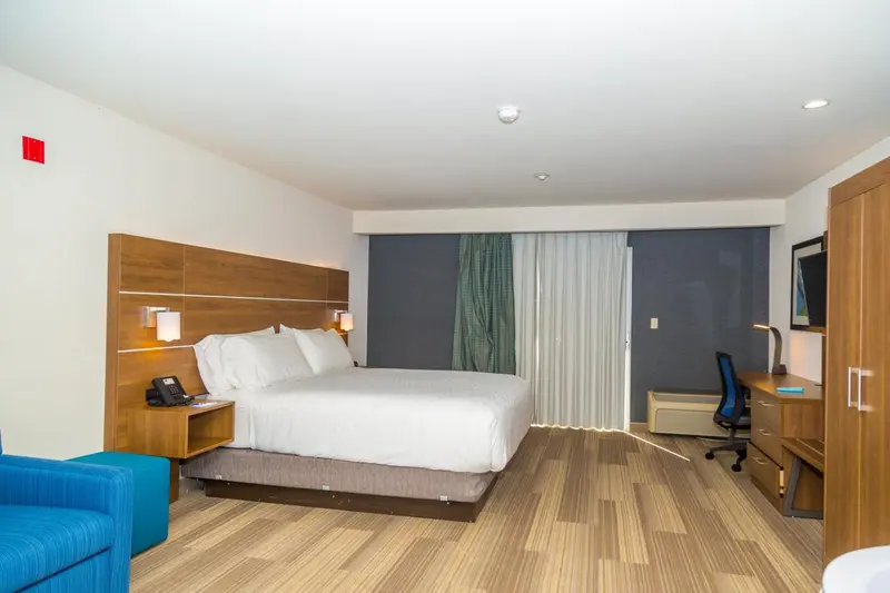 Une chambre d'hôtel lumineuse avec un grand lit et un espace de travail.