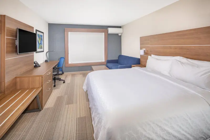 Une chambre lumineuse avec un grand lit et un espace de travail.
