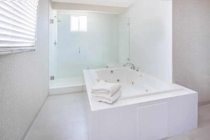 Une salle de bain lumineuse avec une baignoire et une douche vitrée.