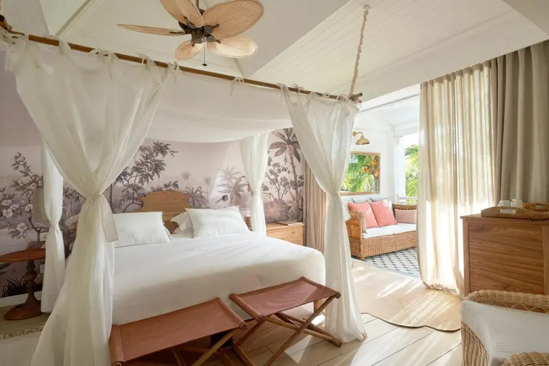 Une chambre lumineuse avec un lit à baldaquin et une décoration florale.
