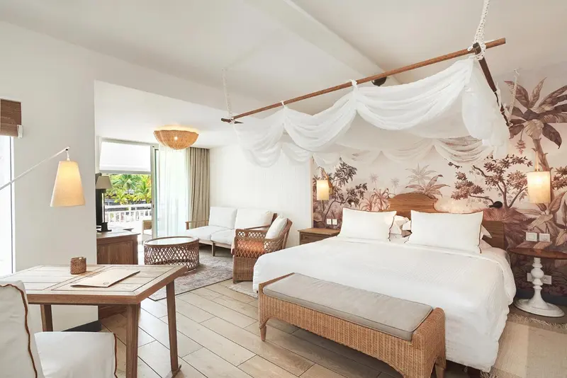 Une chambre lumineuse avec un grand lit à baldaquin et un bureau.