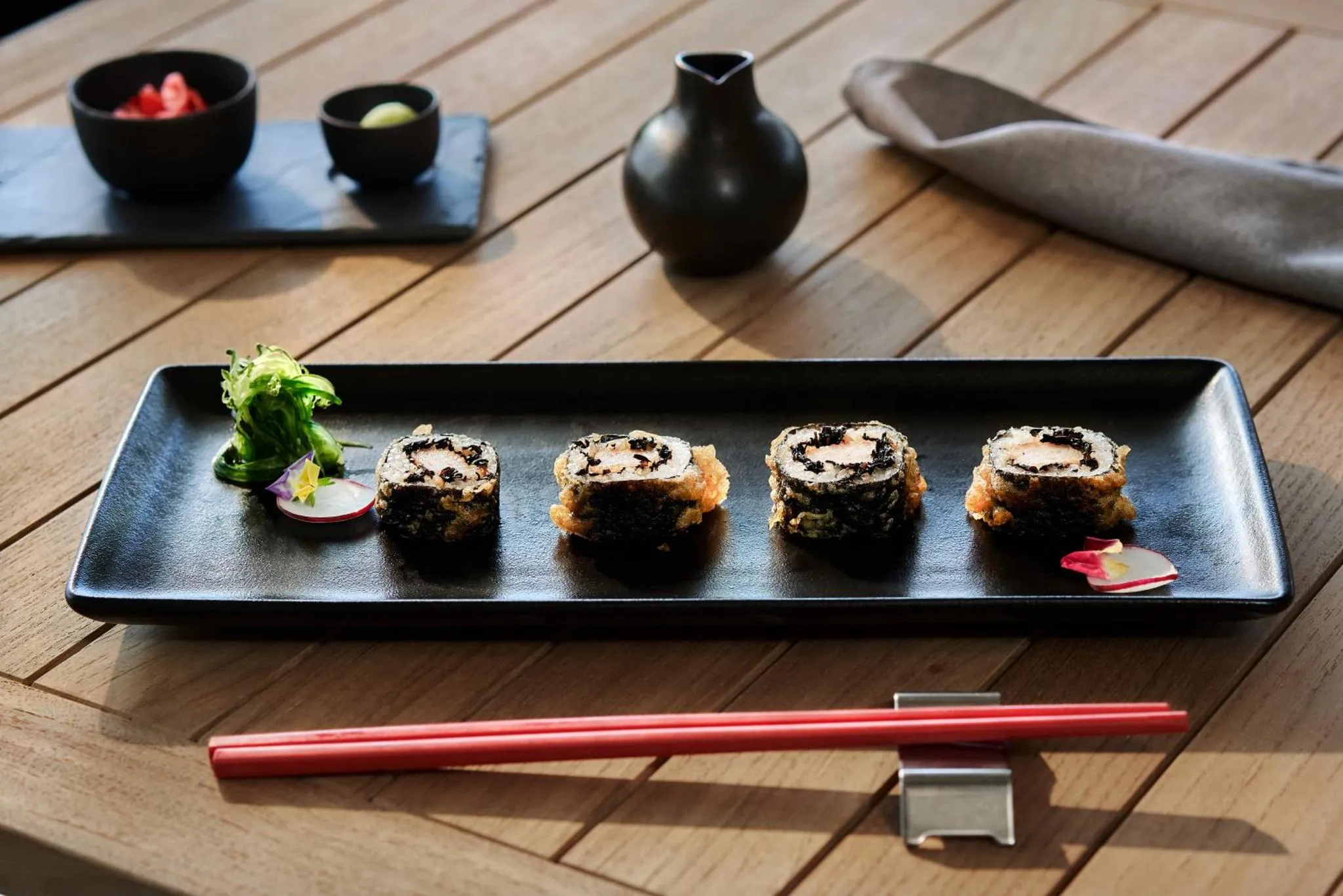 Assiette de sushis présentée sur une table en bois.