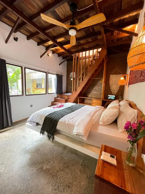 Une chambre à coucher lumineuse avec un lit recouvert de draps blancs et un décor en bois.