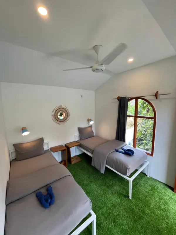 Une chambre avec deux lits simples et une décoration murale.