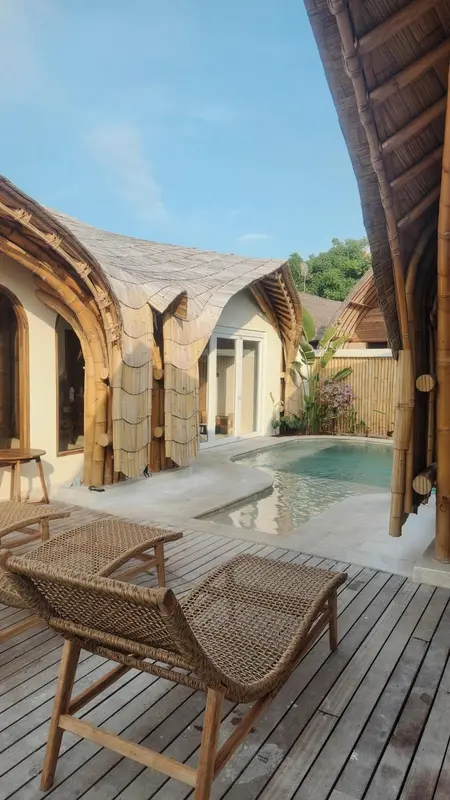 Terrasse avec transats donnant sur une piscine dans une cour intérieure.