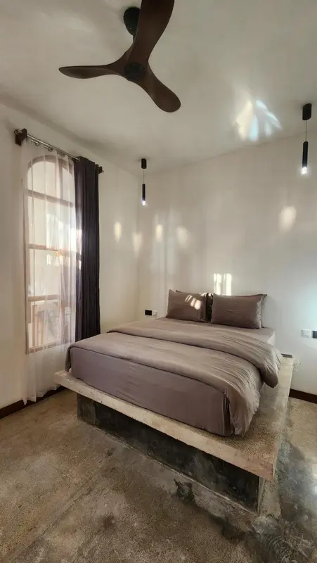 Une chambre lumineuse avec un lit sur une plateforme surélevée.