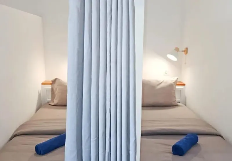 Une chambre avec deux lits simples et des oreillers.