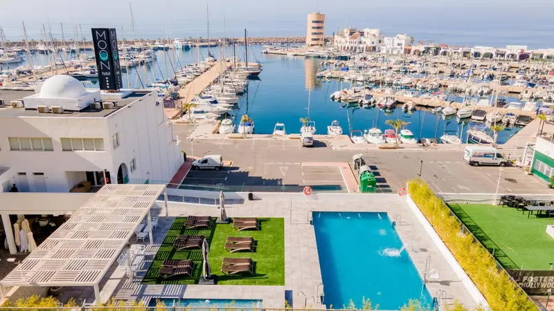 Vue aérienne d'un complexe hôtelier avec piscine et marina.