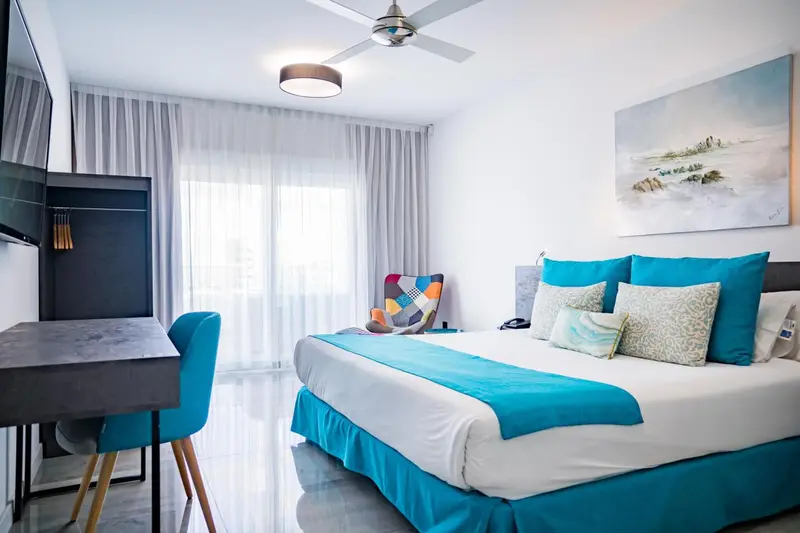 Une chambre lumineuse avec un grand lit et un espace bureau.
